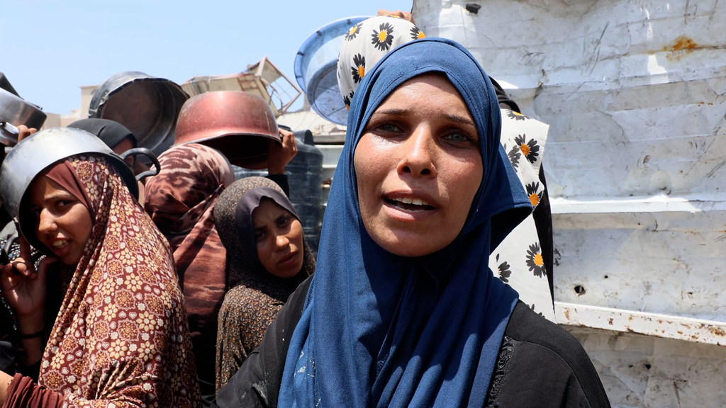 Une femme attend de recevoir de la nourriture à Gaza.